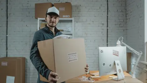 Man carrying storage box looking at camera.