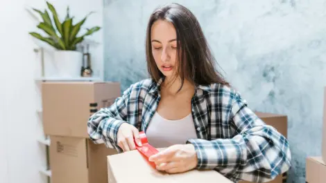 Woman taping storage box.