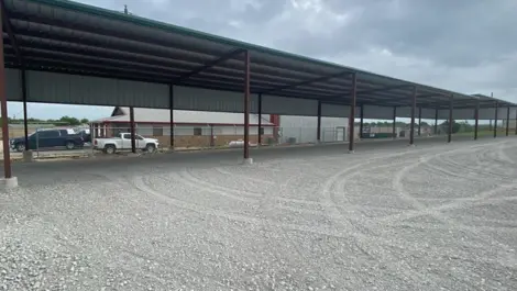Outdoor covered vehicle storage with gravel surface at Rio Vista Mini Storage.