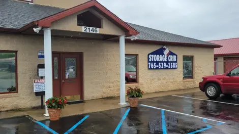 Covered entryway and building facade at Storage Crib with car parked in front.