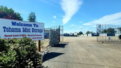 Exterior of Tehama Mini Storage facility with entrance sign and open gate.