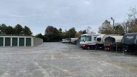 Long rows of drive-up storage units and vehicle storage with gravel access at Volunteer Storage Tellico Village.