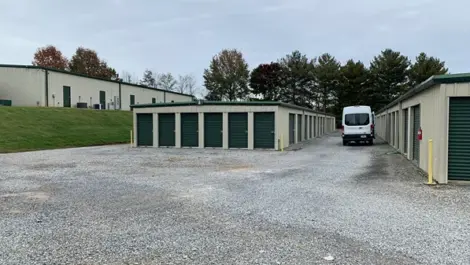 Rows of storage units with gravel surface at Volunteer Storage Tellico Village.
