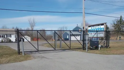 Gated entrance at Hugill Self Storage East with permanent sign in the background.