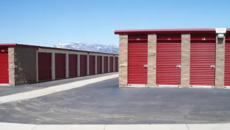 Outdoor drive up access storage units at Alice's Attic Self Storage with mountains in the background.
